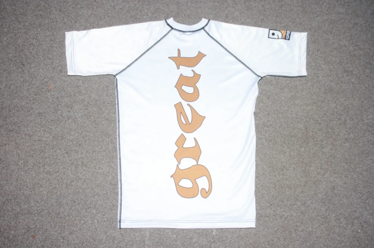 a white rashguard shirt with brown great logo on it